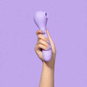 Hand holding the Zena clitoral suction stimulator in a soft lavender Pantone 2635C silicone finish against a matching pastel purple background.